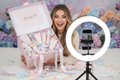 Excited beauty influencer unboxing a luxury PR package with confetti and skincare products